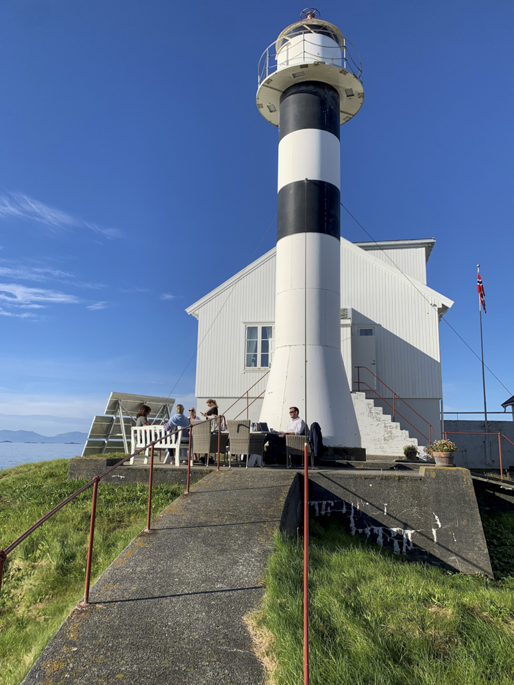 Guests having lunch outdoors on a private lighthouse island in Norway.