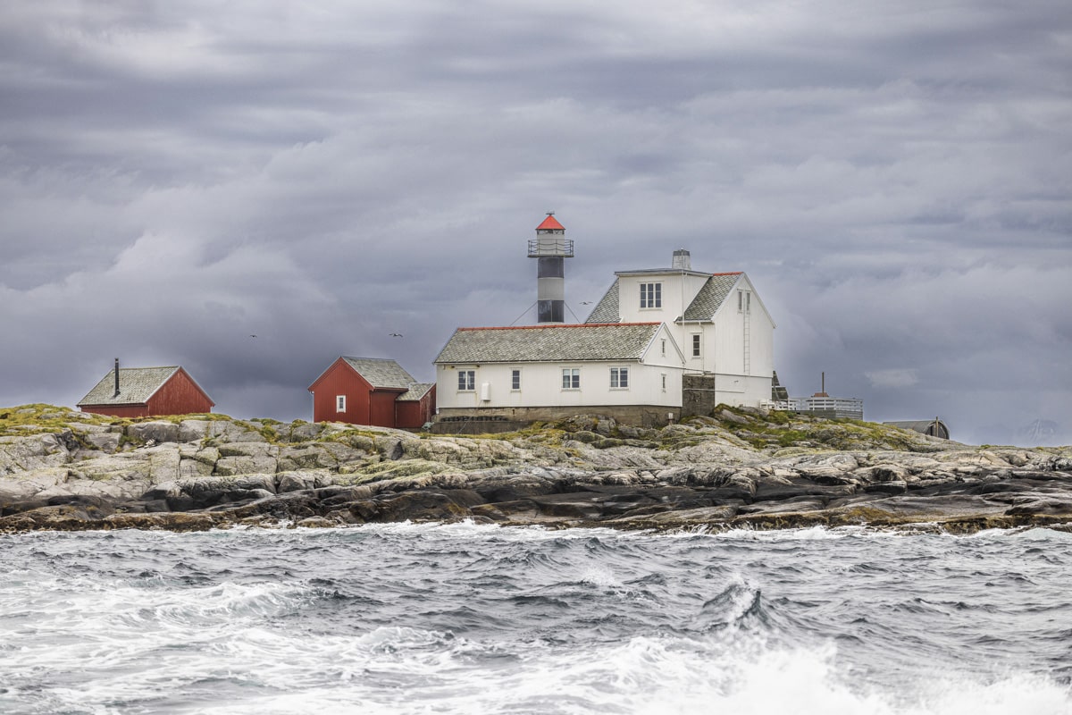 Flatflesa Fyr på en lav holme omgitt av bølger og kraftig sjø.